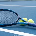 Yonex Ezone 100 tennis racquet on a blue hard court